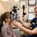 Barn får øjenundersøgelse hos optometrist under medicinsk kontrol